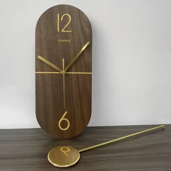 Slingerklok van notenhout met goud