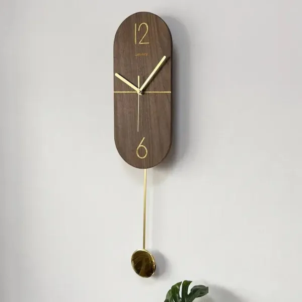 Slingerklok van notenhout met goud